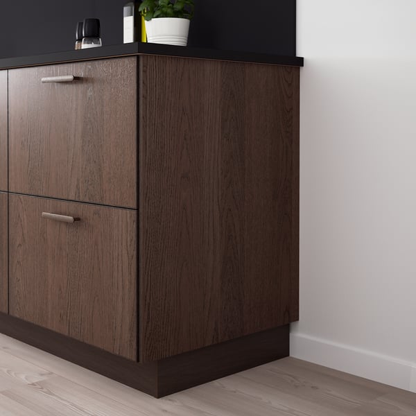 Dark wood SINARP cabinets with sleek handles, featuring oak veneer. Corner cabinet with countertop, slightly taller than surrounding units.