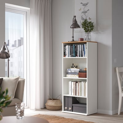 White SKRUVBY bookcase with books, decor, plant, lamp, next to sofa & window.