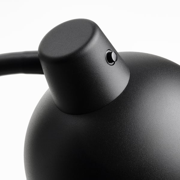 Black adjustable lamp with textured surface and round design.