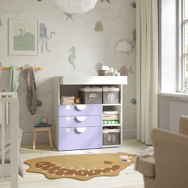Nursery with SMÅSTAD changing table. Light purple storage drawers, white top. Soft rug, natural light. Decor with sea creatures.
