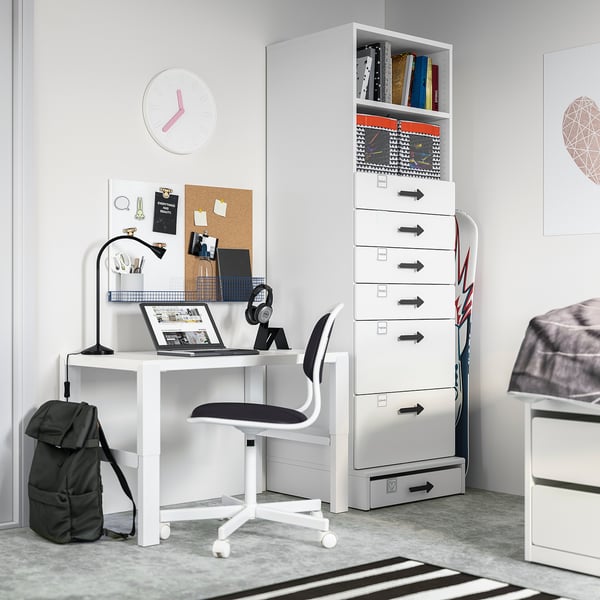 A minimalist white home office setup with desk, chair, and storage unit featuring shelves and drawers for organisation.