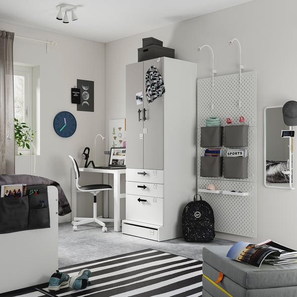 Modern teen room with white SMÅSTAD wardrobe, black accents, striped rug, and organised study space.