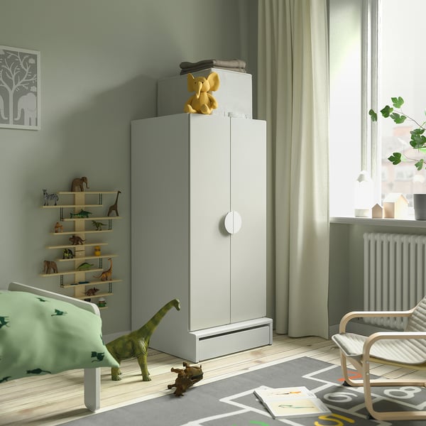 A childs bedroom with a large SMÅSTAD cabinet holding toys next to a bed and window.