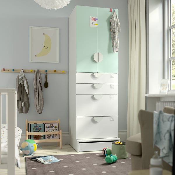 SMÅSTAD kids wardrobe in light blue/white, tall, soft-close drawers, near window, with rug and toys.