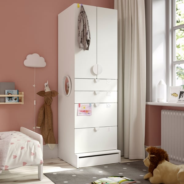 SMÅSTAD wardrobe in pink room. Tall, narrow, with drawers, shelves, soft-closing hinges. Giraffe toy, polka dot rug, cosy kids space.