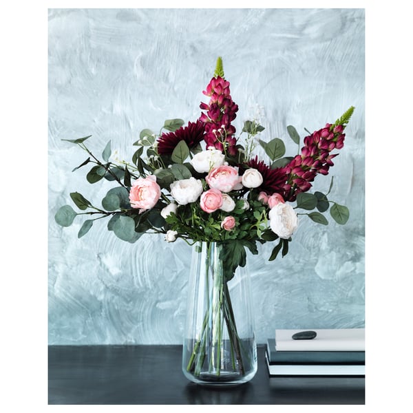 SMYCKA bouquet: pink & purple flowers in clear recycled glass vase on table.