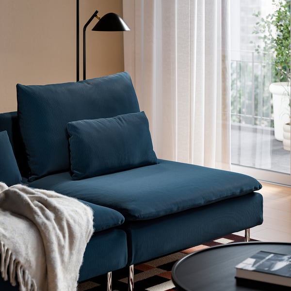 A blue fabric sofa with back cushions for support, high legs, and a side table nearby.