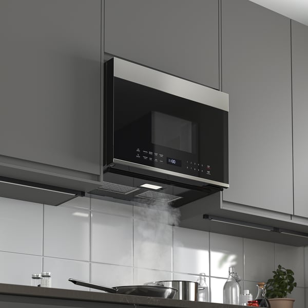 Modern kitchen with built-in microwave oven and range hood, showcasing its sleek design and functional ventilation.