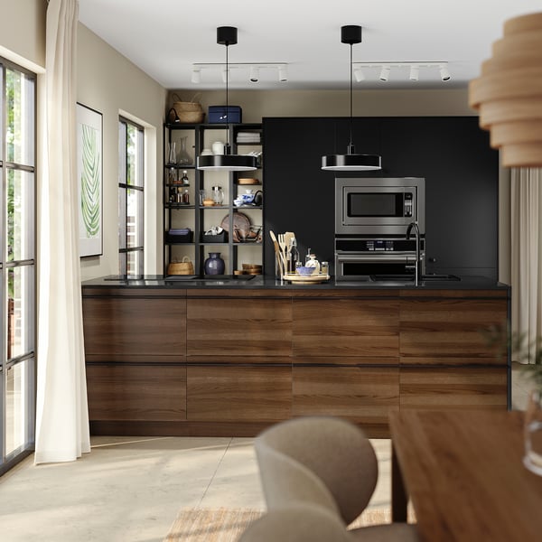 Modern kitchen with dark brown stained wood cabinets, stainless steel appliances, and open shelving with dishes and utensils.