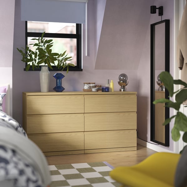 Modern light brown wooden chest with drawers, 6 drawers, shiny objects, plant, mirror, simple, bedroom with plants.