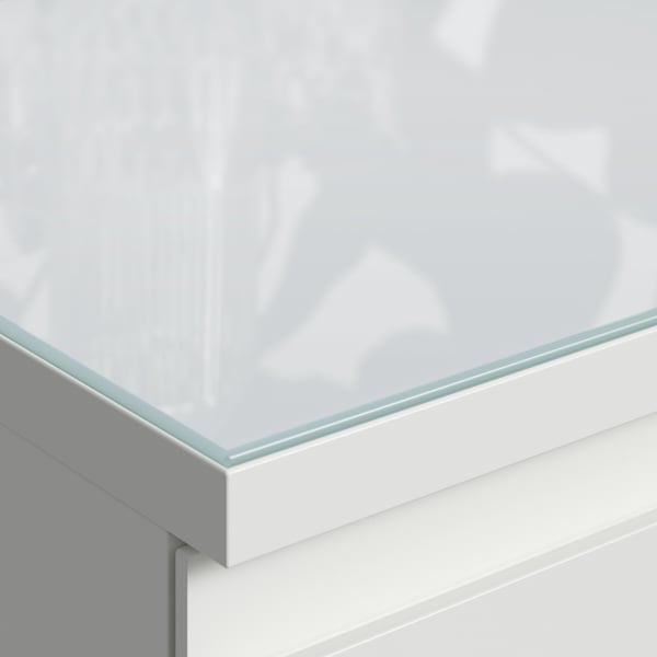 A clear glass top, designed to fit a white chest of drawers, protecting and enhancing its modern look.