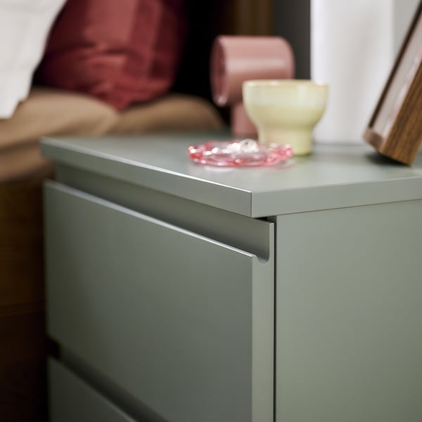 STORKLINTA bedside table made of sturdy greenish-gray laminate. Two smooth-running drawers and simple integrated handles.