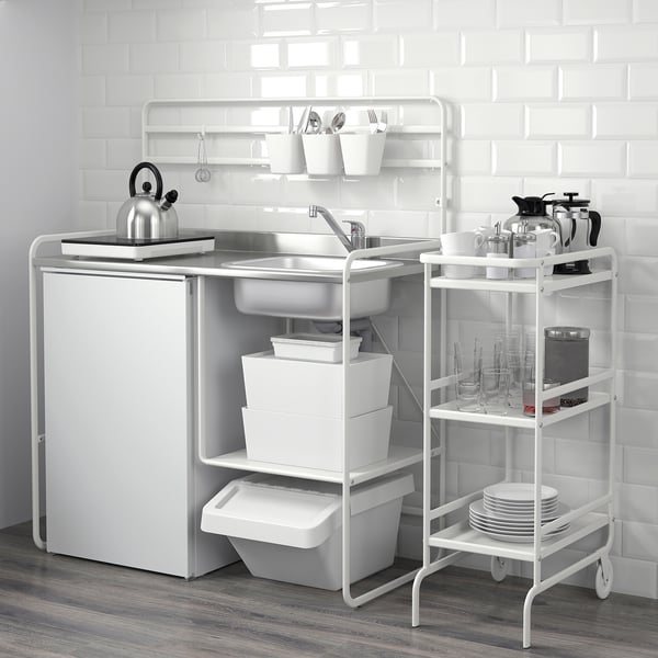 Mini-kitchen setup with sink, shelves, and utensils, perfect for compact spaces. Includes storage bins and a kettle.