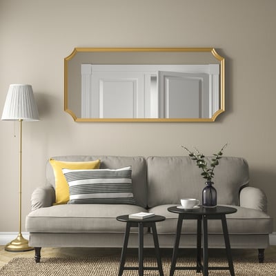 Living room with large SVANSELE mirror over grey sofa, larger than lamp and coffee table.