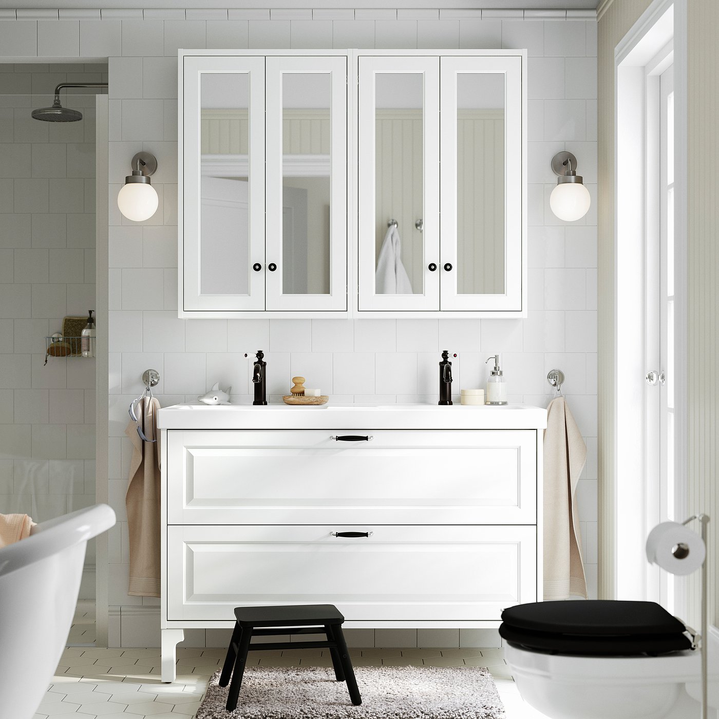 Modern bathroom with TÄNNFORSEN vanity, stool, lights, & white tiles. Mirrored cabinets, drawers, marble countertop, freestanding tub, & toilet.