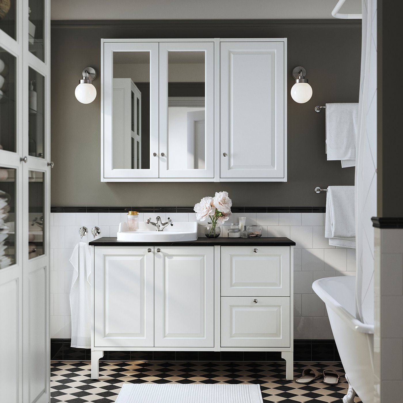 Elegant bathroom with white TÄNNFORSEN vanity, black countertop, checkerboard floor, and mirror cabinet.