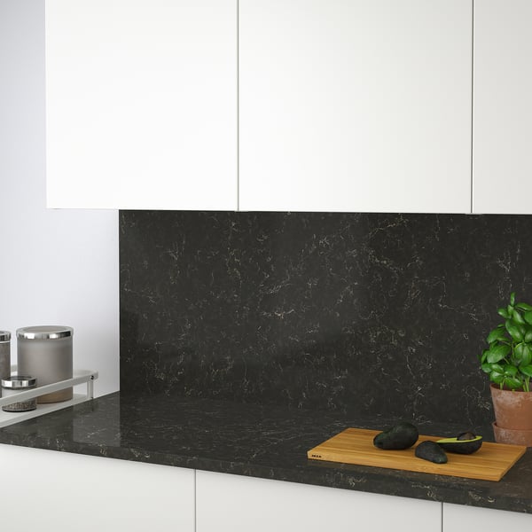 Modern kitchen with black marble-look recycled glass counter & backsplash. Stain-resistant, ideal for stove cleaning.