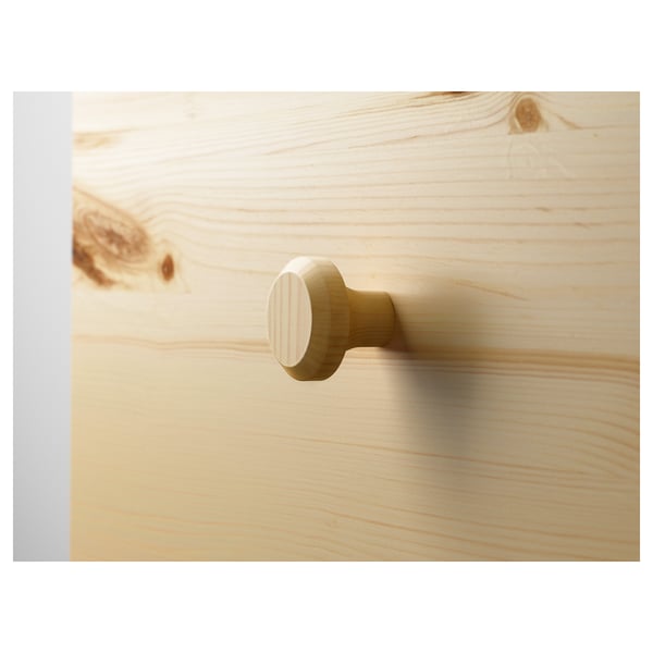 Close-up of round wooden knobs on a light-colored wooden surface, highlighting the natural grain and smooth finish.
