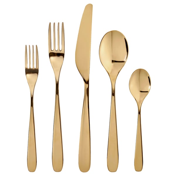 Gold-colored TILLAGD cutlery set, includes fork, knife, spoon, and teaspoon. Sleek, metallic design. Shiny brass finish.