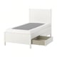 A white TONSTAD bed with a grey mattress and open drawer, sleek minimalist design.