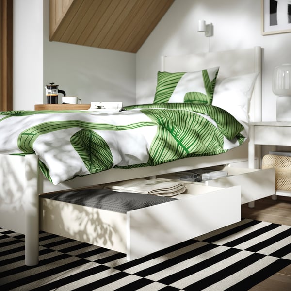 Modern bed with two open drawers; off-white with soft-close feature.