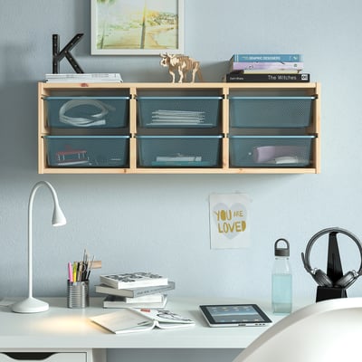 TROFAST shelf with mesh boxes in bedroom. Holds books, papers, with painting, lamp, tablet above and below.