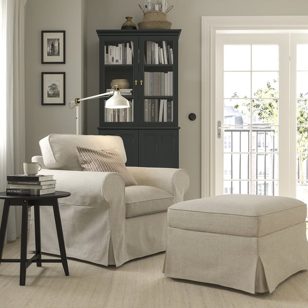 Comfy UPPLAND armchair, beige ottoman, bookshelf, side table, lamp in modern-classic living space.