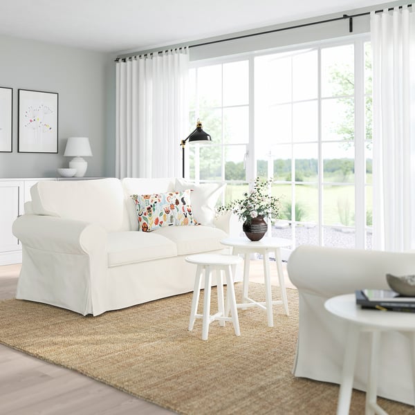 Bright living room with large windows, UPPLAND sofa, side table, and beige rug.