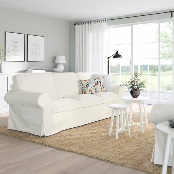 Living room with UPPLAND sofa, colourful pillows, wood floors, big windows.