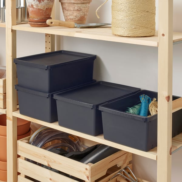 Wooden shelf with three dark grey UPPSNOFSAD boxes storing gardening tools and supplies.