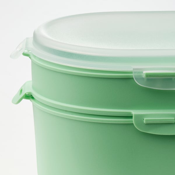 Two green plastic containers nested inside each other with secure lids, ideal for packing lunch.