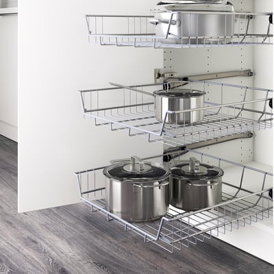 Wire storage baskets, ideal for pots and pans, mounted inside a cabinet with pull-out stops for easy access.