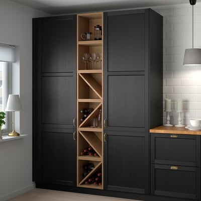 A VADHOLMA black wooden storage unit in kitchen, holding bottles and glasses, combining practicality with style.
