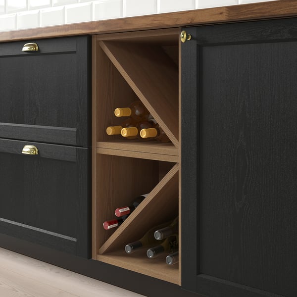 Black kitchen cabinet with wooden wine shelf holding multiple bottles, mounted between cabinets.