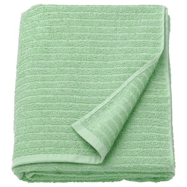 Folded light green VÅGSJÖN bath towel, made of 100% cotton, with a soft, textured surface and overlocked edges.