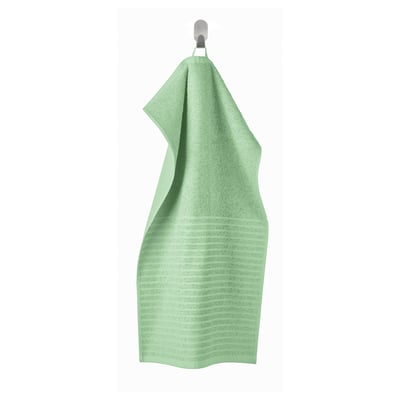 Light green VÅGSJÖN towel hangs neatly on a hook, showcasing its soft, textured terrycloth design.