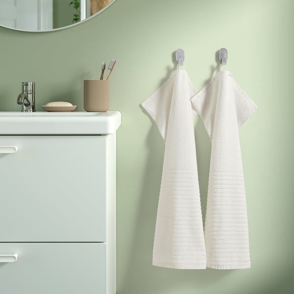 Bathroom with VÅGSJÖN towels on hooks beside a white vanity.