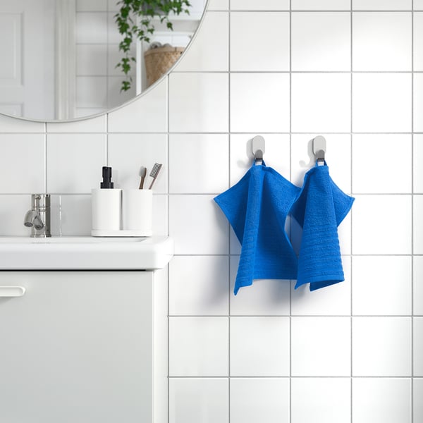 Blue VÅGSJÖN towel hangs beside sink. Bright colour, soft cotton. Medium size, styled neatly.