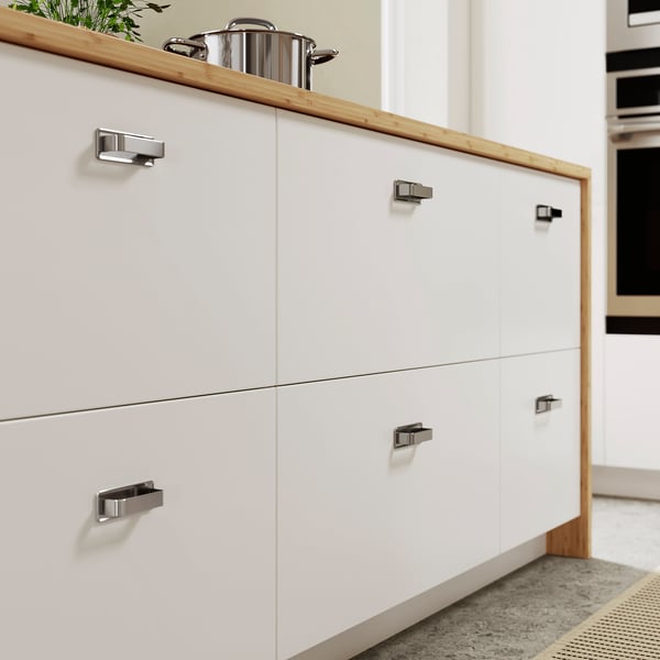 Modern kitchen with white VEDDINGE cabinets, sleek handles, clean lines.