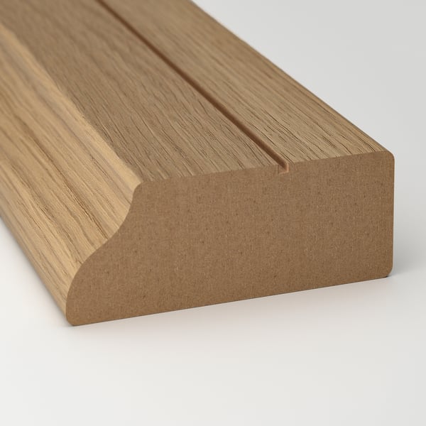 Close-up of high-quality oak wood trim. Smooth, even grain, rich natural tone.