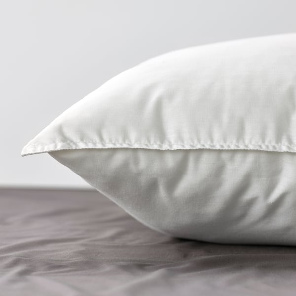 Clean, white pillow on bed. Soft, firm and plumped, with smooth edges and high-quality fabric.