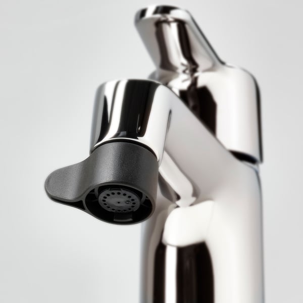 Close-up of chrome-plated tap nozzle, featuring ergonomic design with spray or mist modes, positioned on shiny, reflective tap handle.