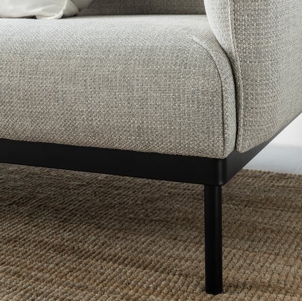 A modern, grey fabric sofa with slim black metal legs.