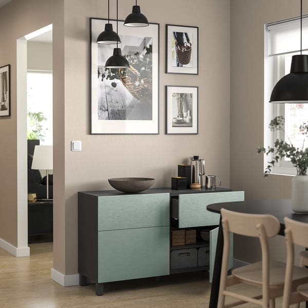 Modern room with teal BESTÅ storage unit, black pendant lamps, and wooden chair.