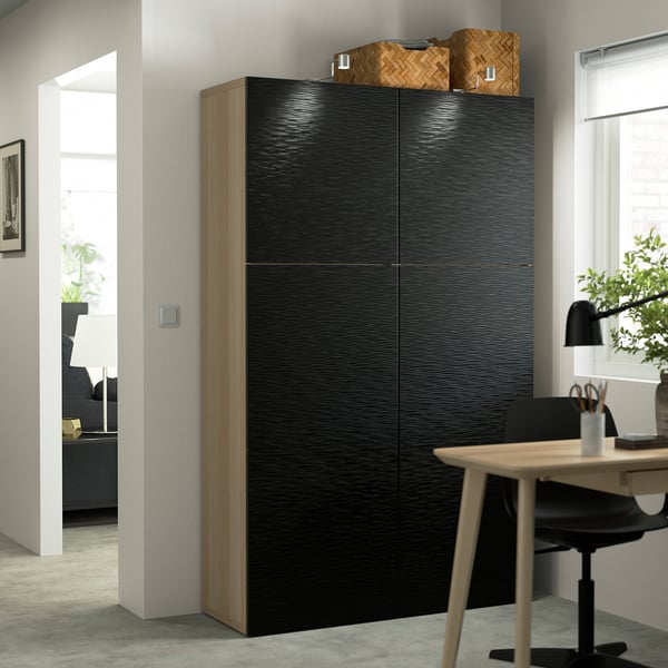 BESTÅ cabinet with wicker baskets in office space, desk, chair, plant.