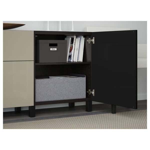An open storage cabinet with shelves holding boxes and books. The cabinet has soft-closing drawers and doors with silver hinges.