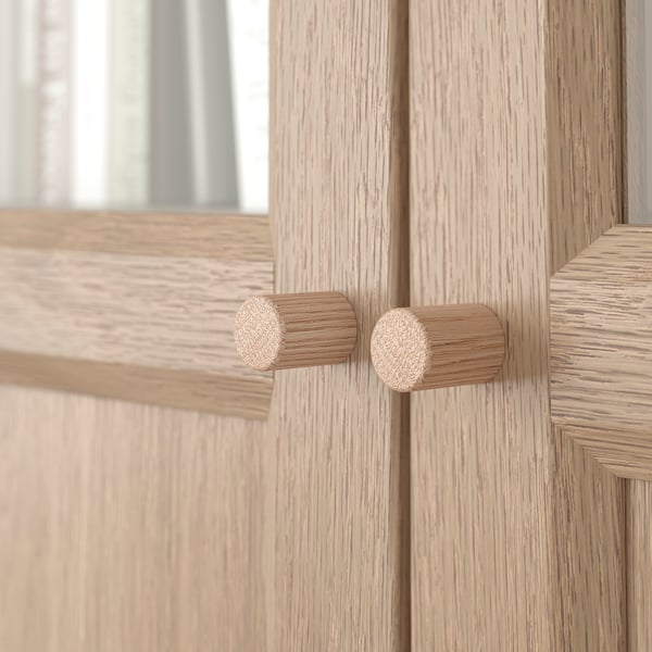 Light wooden cabinet with two circular knobs, showcasing high-quality grain texture and sturdy build.