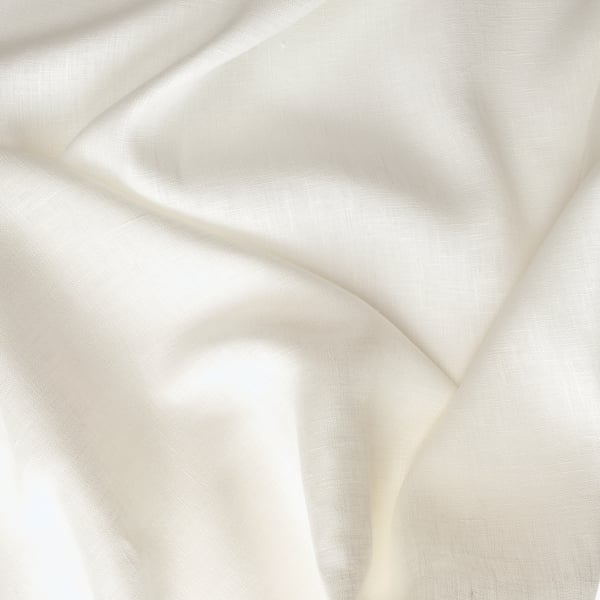 Soft, white linen fabric crinkled into gentle folds, showcasing the natural texture and quality of the material.