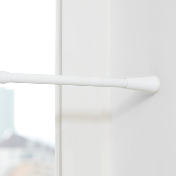White curtain rod attached to a window frame, showcasing sturdy design and easy installation with rubber caps.