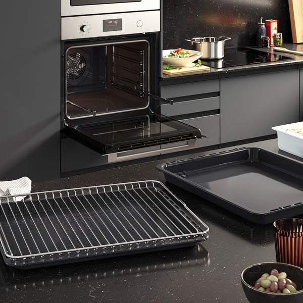 Modern kitchen with open oven, showing FRILLESBOs sleek design, baking trays, and digital controls.
